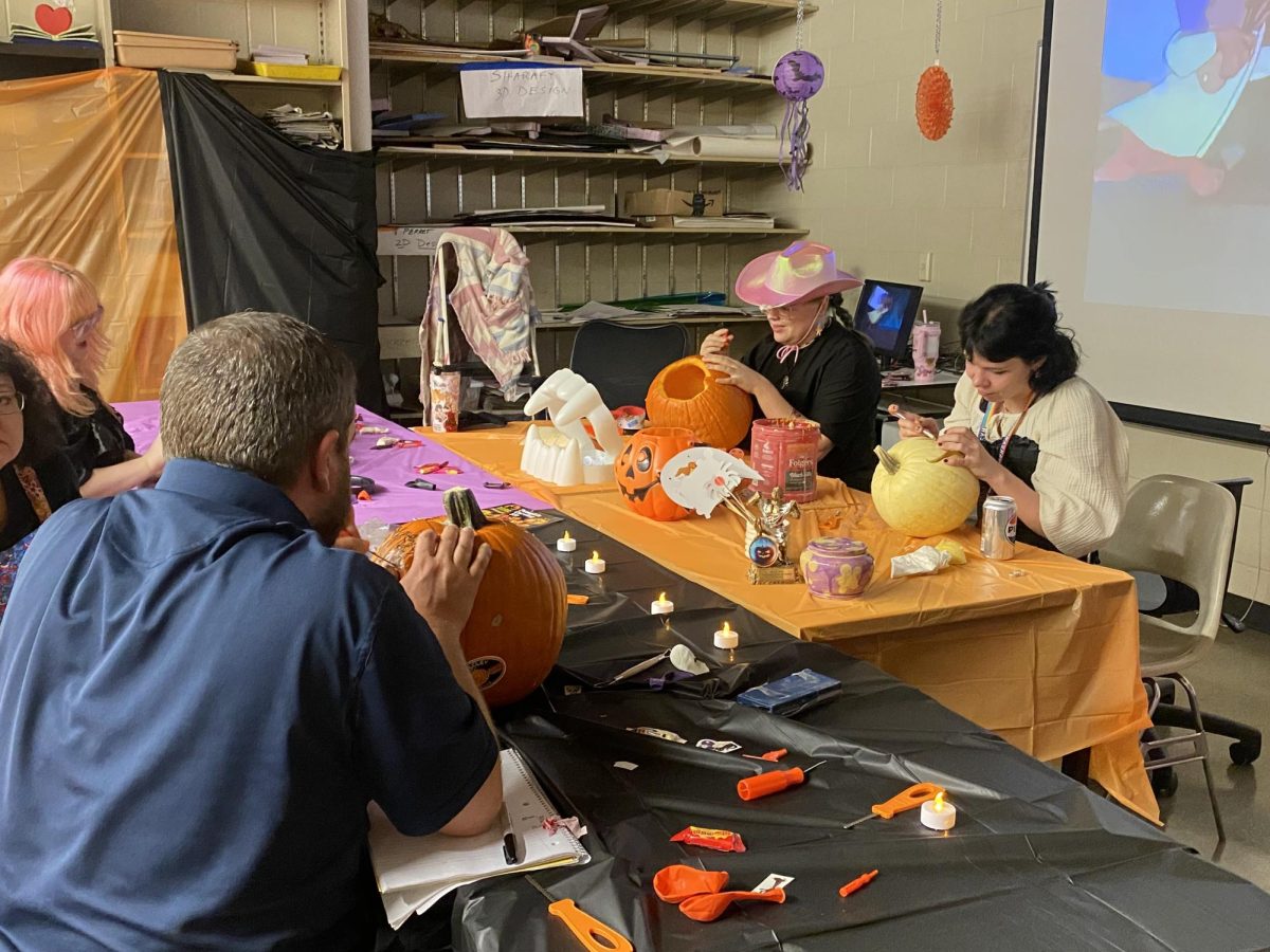 Conner Sowles, president of Washburn art club, along with others, takes part in pumpkin carving. Everyone eagerly scooped out the insides of the pumpkins.