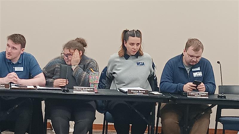 WSGA Senate listening to the cabinet calling roll call. Ryan Durst, Kirstyn Brown, and Cameron Billquist settled in waiting for their names to be called. 