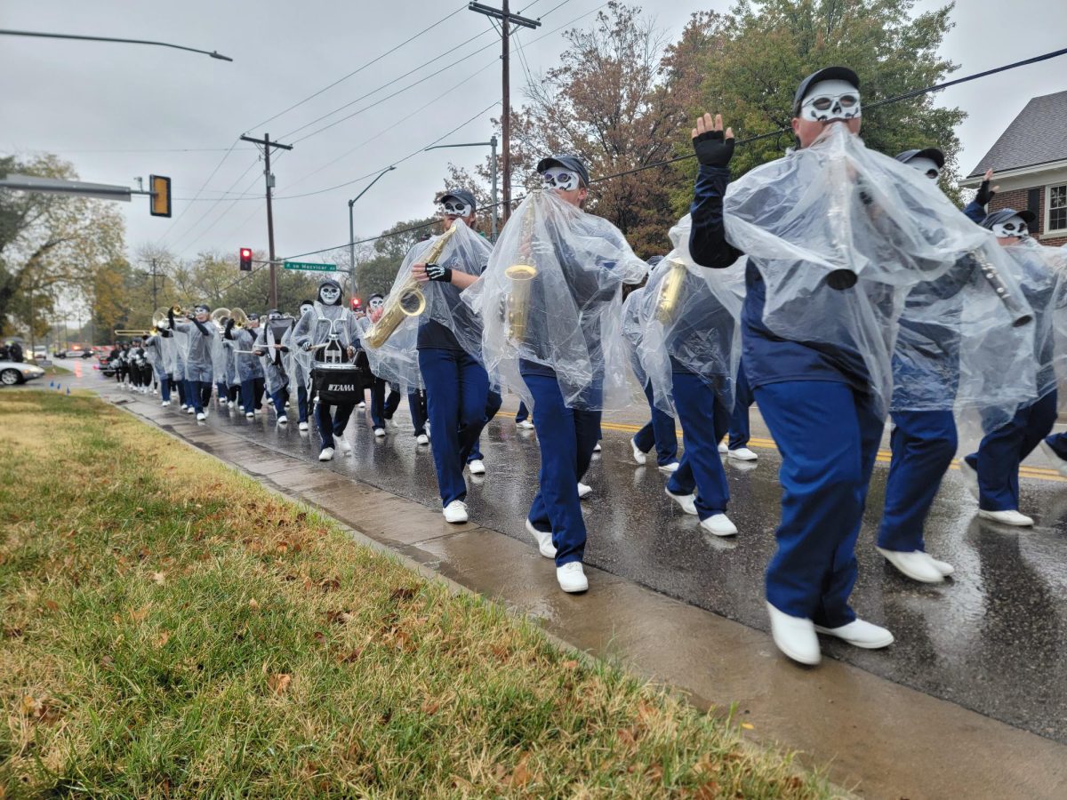 The Washburn University Marching Band plays in theme as they march down 17th Street. The rain was an obstacle but did not stop the show.