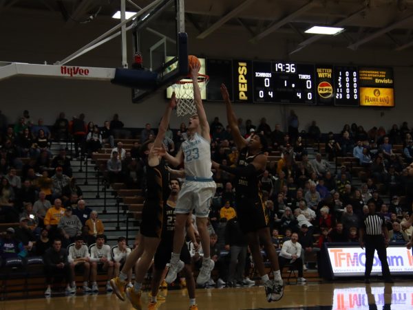 Michael Keegan, senior guard, scores another basket for the Ichabods.
Three players from the other team tried to stop him.
