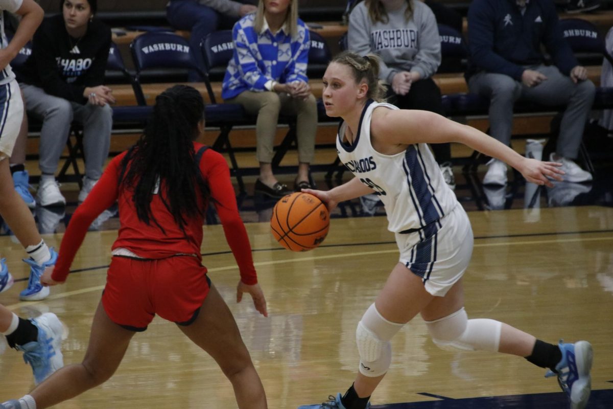 Payton Sterk, junior guard, dribbles past defenders, looking for an open shot. Sterk led all players in scoring with 24 points.