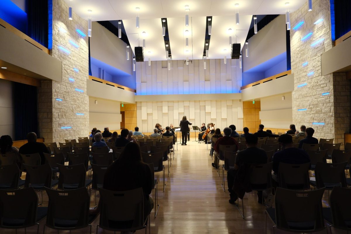 Cipriano conducts the Washburn University String Orchestra under the indigo lights of the recital hall. The hall is the newest addition to the Garvey Fine Arts Center.