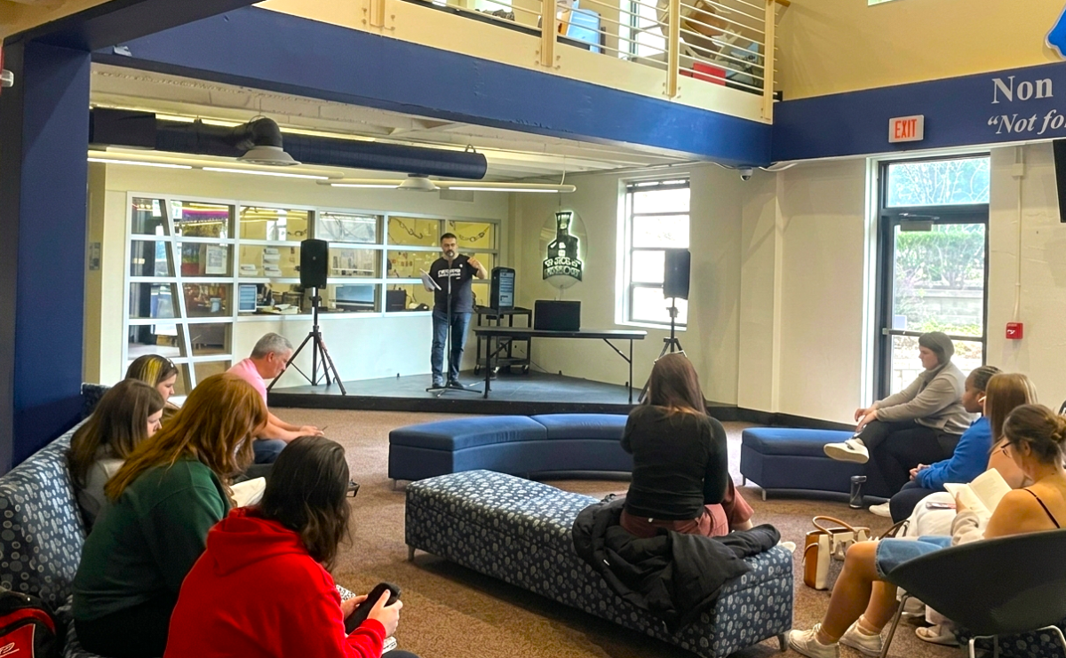 Dennis Etzel Jr., senior English lecturer, opens the Ichabods Speak Out open mic poetry, introducing the organizations present at the booths. Washburn students were encouraged to take breaks as needed, including splashing water on their face to refresh. 