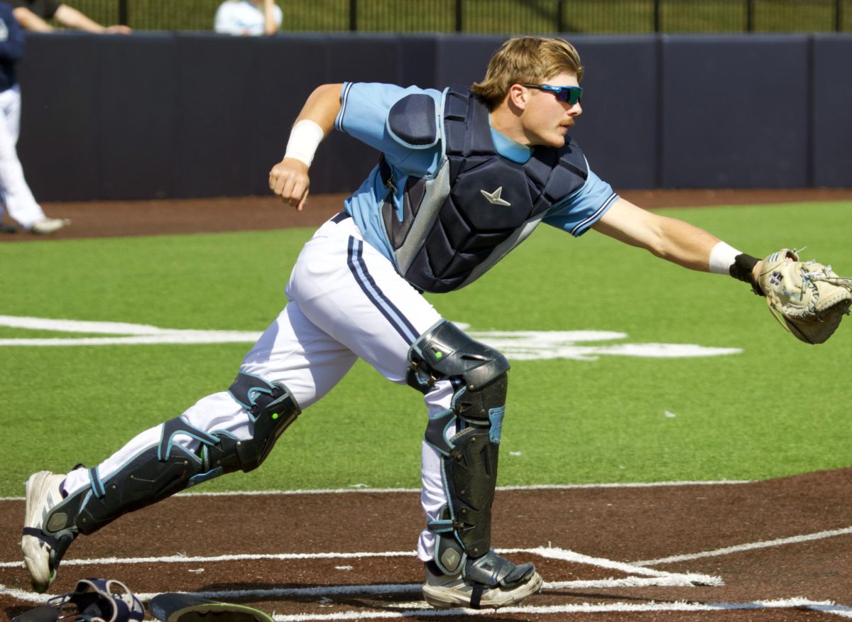 Sophomore catcher Brooks Richardson throws off his mask, runs up and prepares to throw an out to first base. Richardson served as the catcher the entirety of the game.
