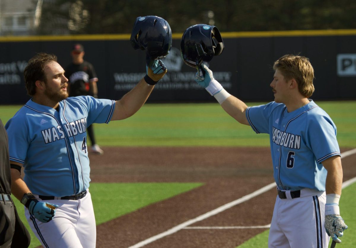 Freshman infielder Easton Wasinger (left) meets sophomore catcher Brooks Richardson (right) at home plate, tapping their helmets together in celebration. Richardson gave Washburn their first run with a solo home run.