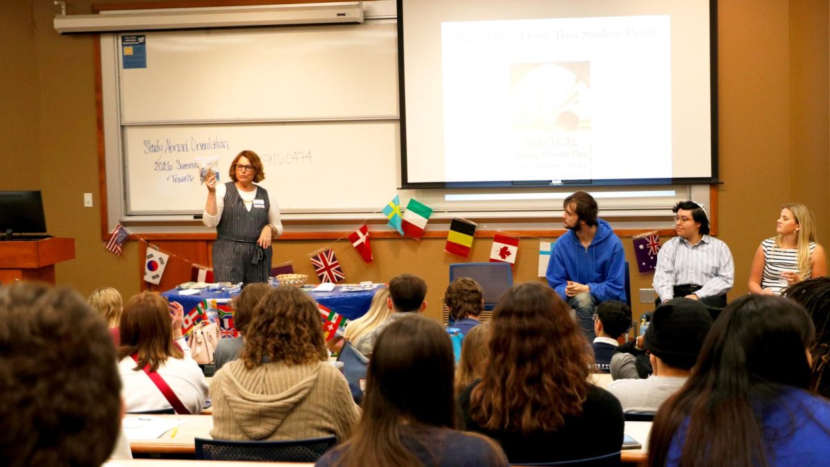 Tina Williams, study abroad director, demonstrates kits and gear that are helpful for the trip at the pre-departure orientation. A table was set with specialized items that could improve TSA experiences and tools for safety. 