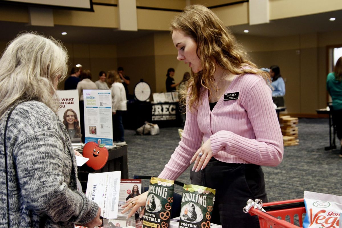Lauren Darrah, corporate Hy-Vee dietitian, presents fiber-rich snack samples to participants at Wellness Fair. Students were provided with healthy food options and nutritional information during the event.