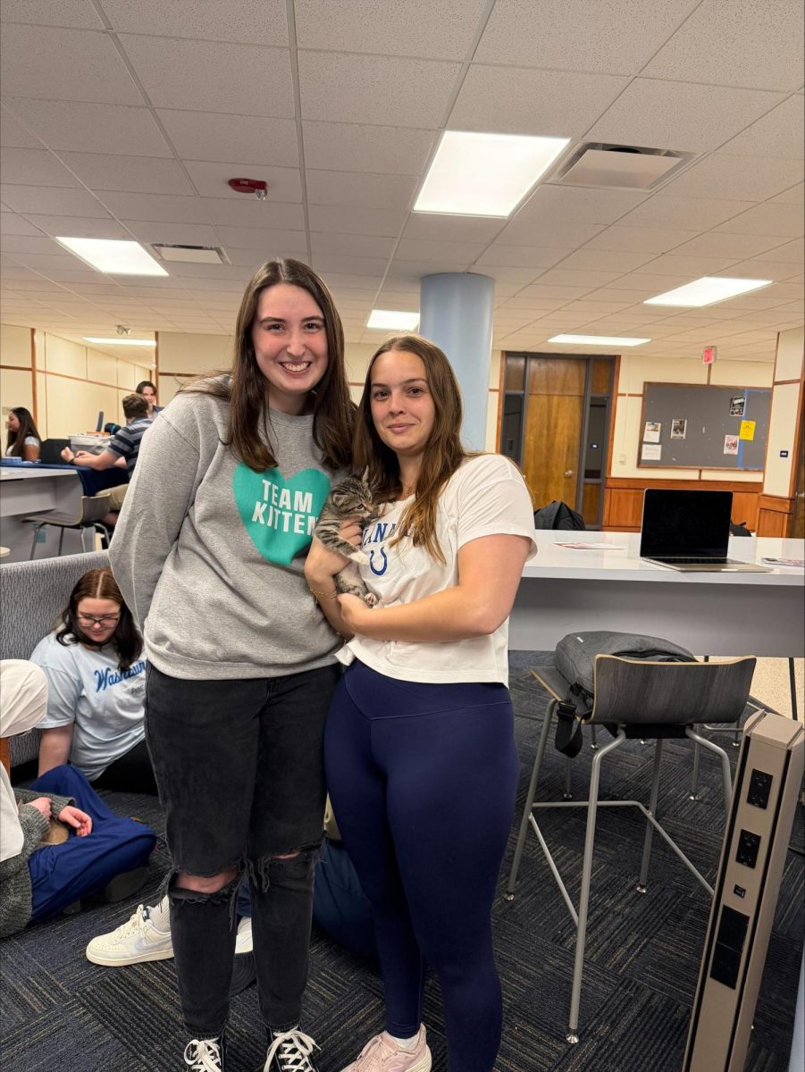 Erica Guldner, senior biology major and volunteer for Team Kitten, poses with Grace Wright, senior biology major, holding up a kitten. The event provided opportunities for students to play with kittens and learn more about the organization, and volunteering for Team Kitten.